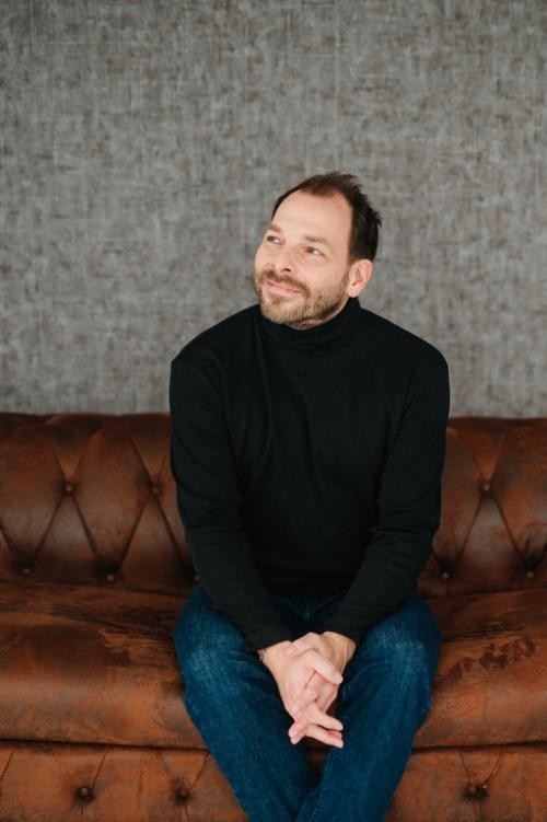 Martin Bayer auf einem Sofa sitzend Martin Bayer auf einem Sofa sitzend