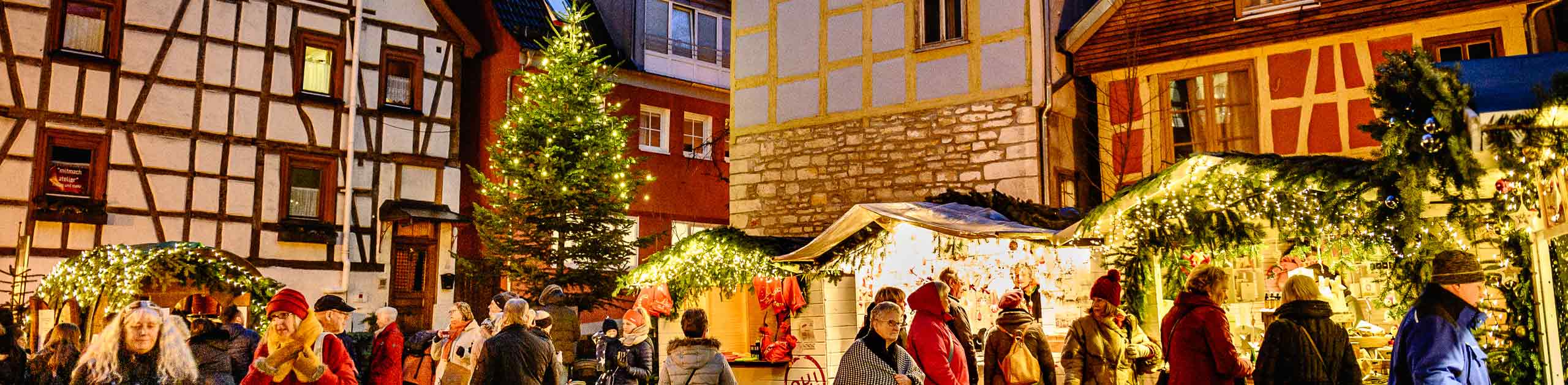 Weihnachtsmarktstände, Menschen, beleuchteter Weihnachtsbaum, Foto: Oliver Vogel