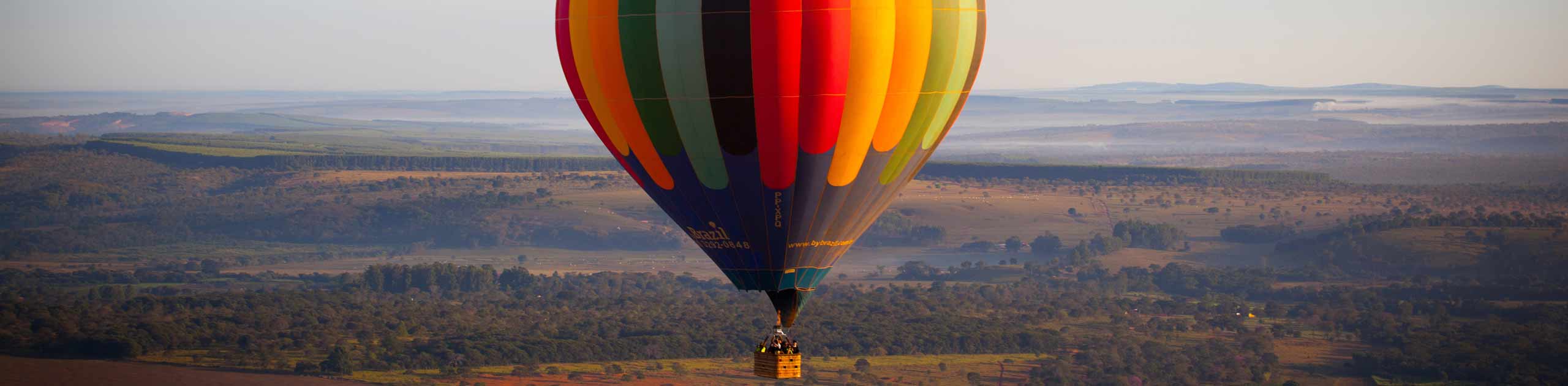 Farbiger Heißluftballon schwebt über einer Heide, Foto: Enrico Dias Enrico auf Pixabay